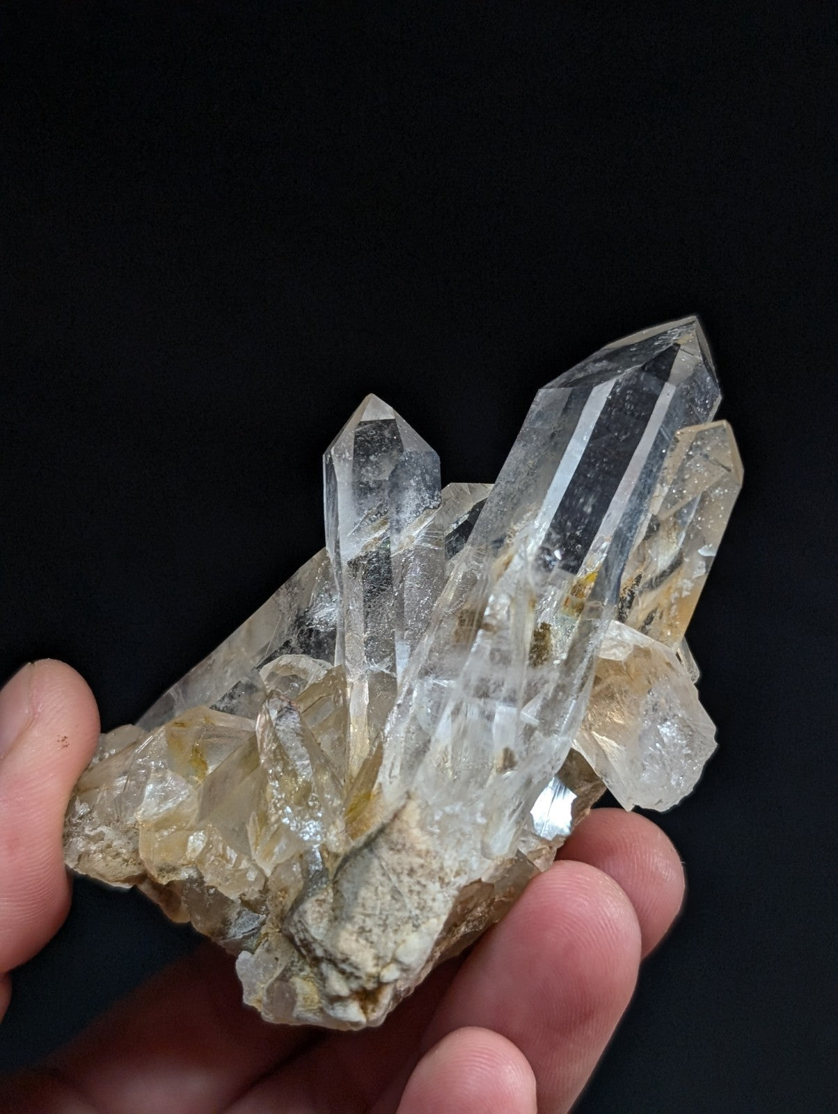 A clear quartz crystal cluster with sharp, faceted points and a translucent quality.