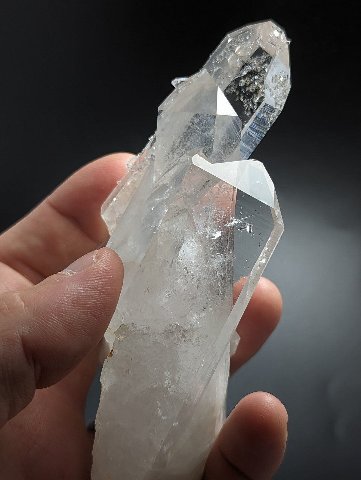 A clear, translucent quartz crystal cluster with sharp geometric facets and a natural, slightly cloudy appearance.