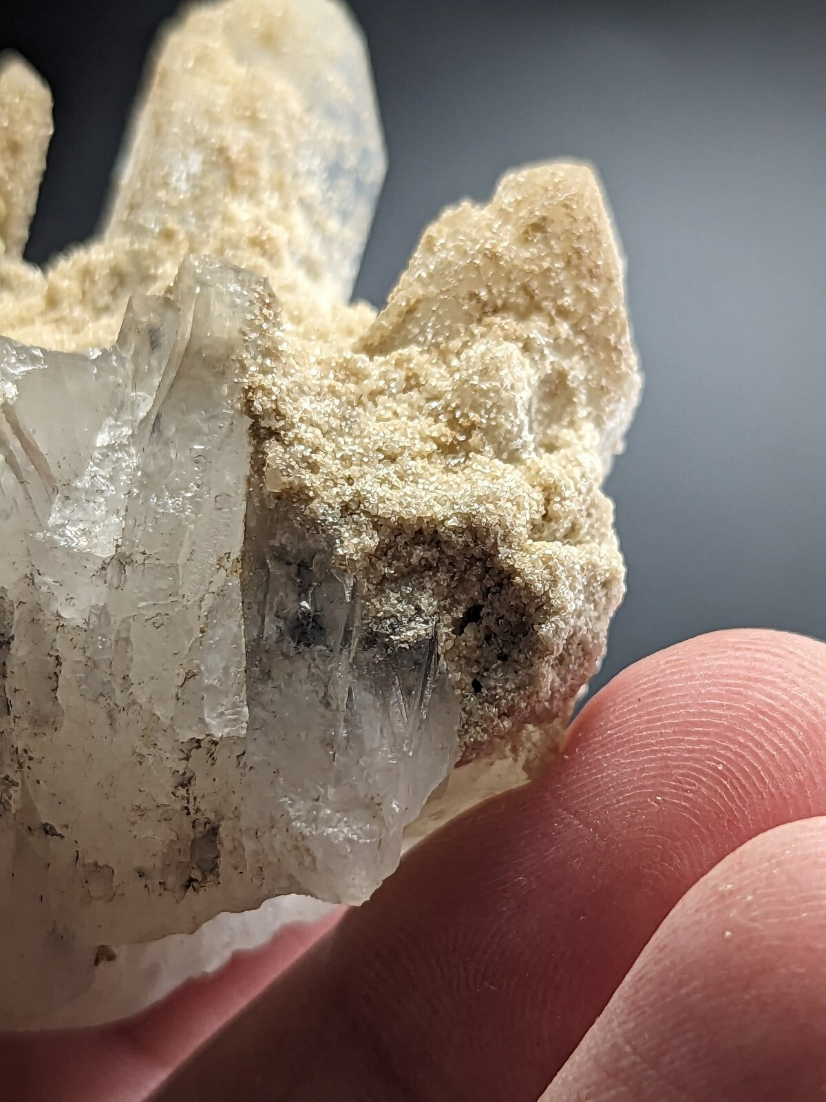 A translucent quartz crystal cluster with sharp, pointed formations and a pale beige matrix.