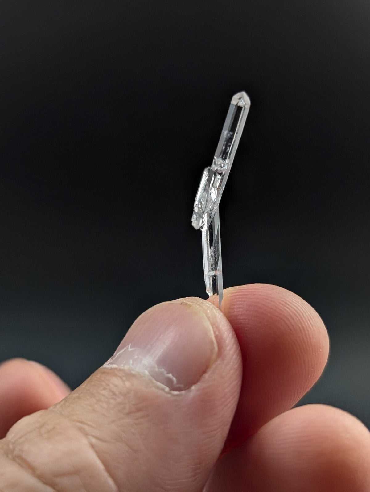 A clear, transparent quartz crystal with a pointed tip and natural facets.