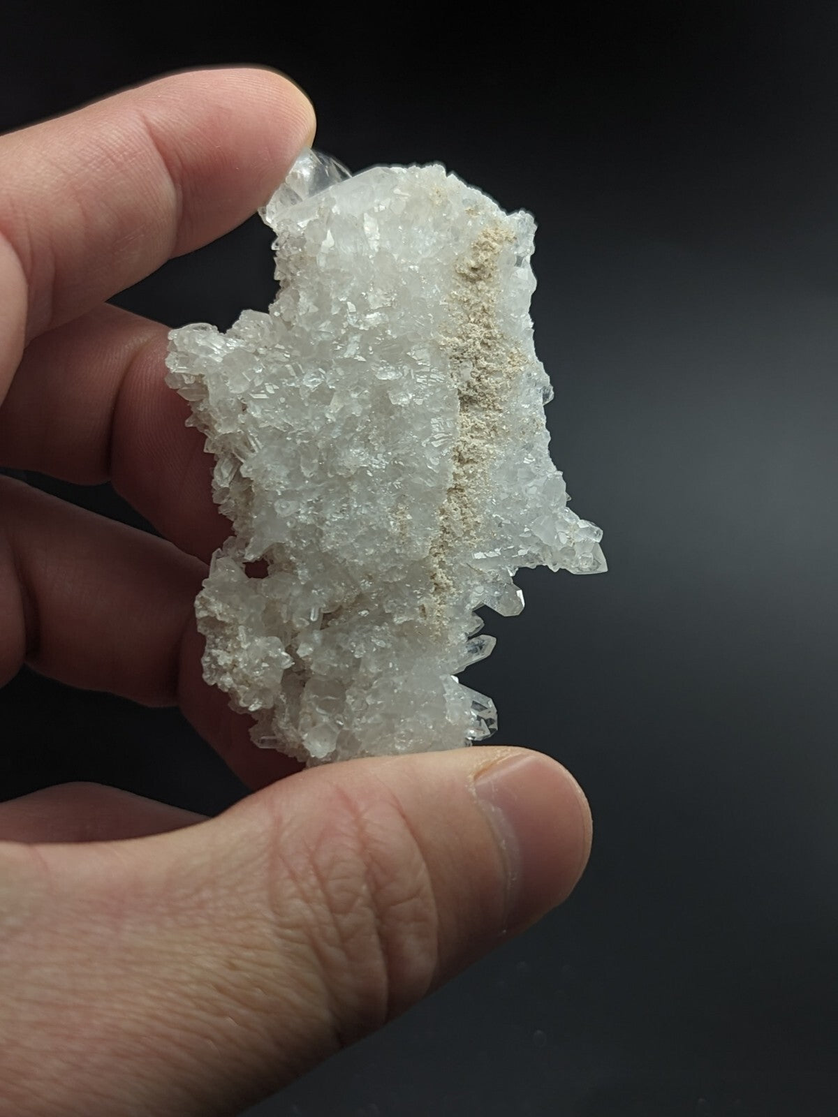 A translucent white crystal cluster with a rough, jagged surface and subtle golden streaks.