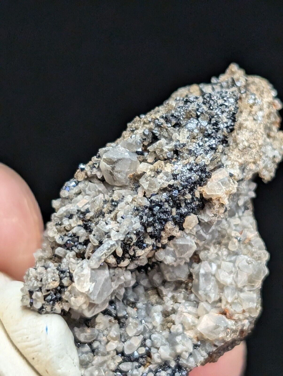 Cluster of quartz crystals with dark metallic inclusions.