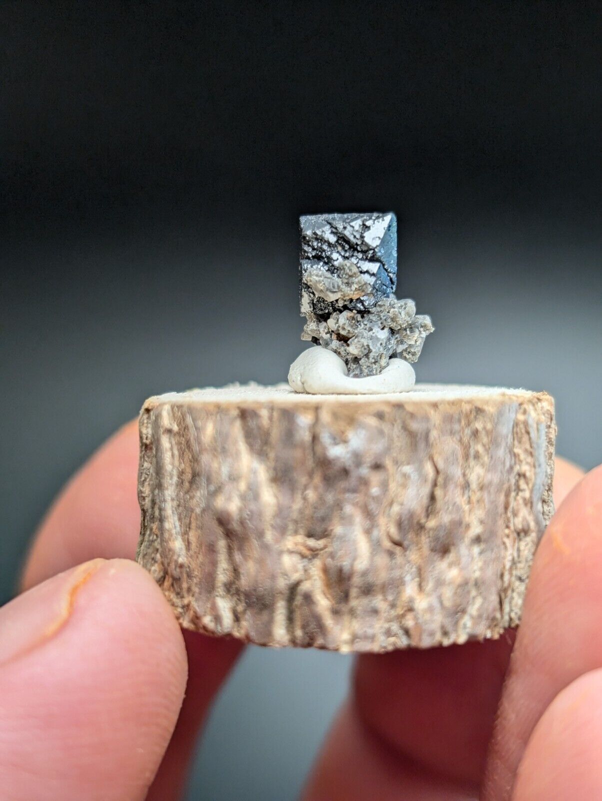 Metallic crystal specimen on a wooden base.