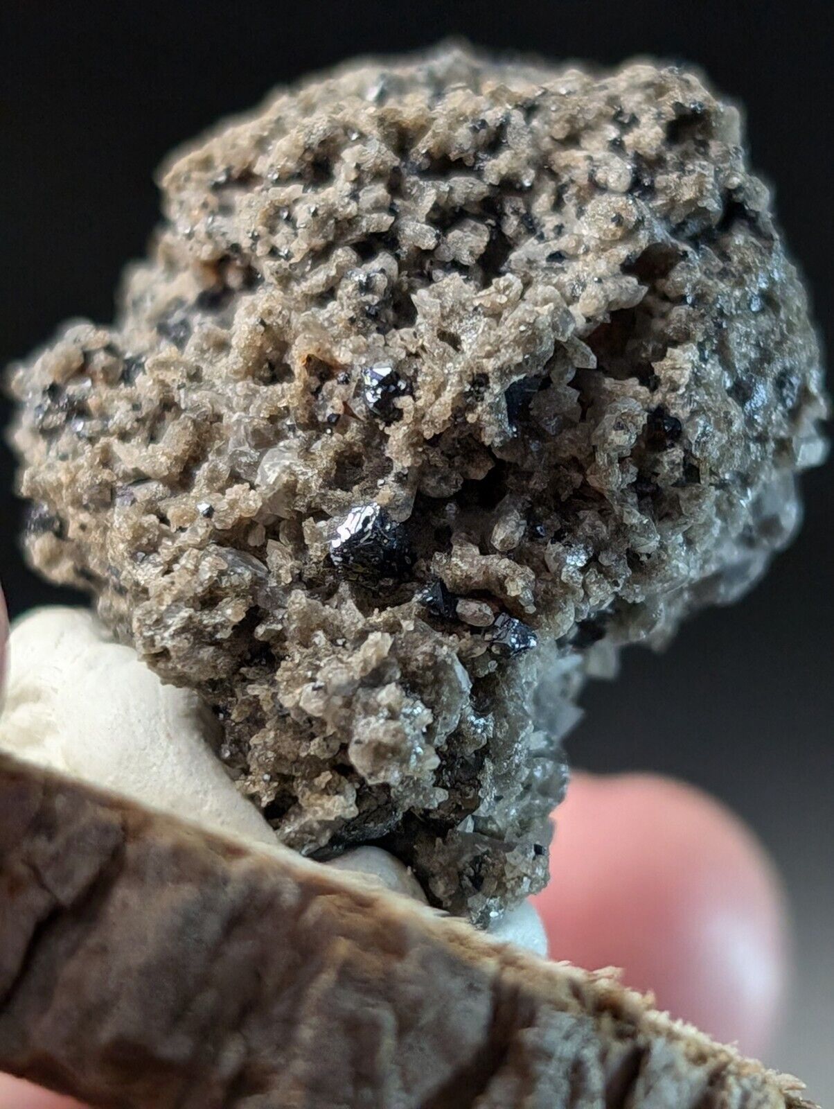 Clustered gray mineral with dark inclusions.
