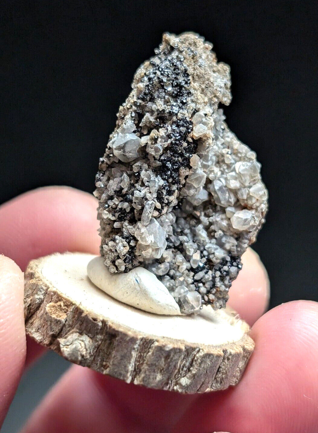 Cluster of quartz crystals with black inclusions.