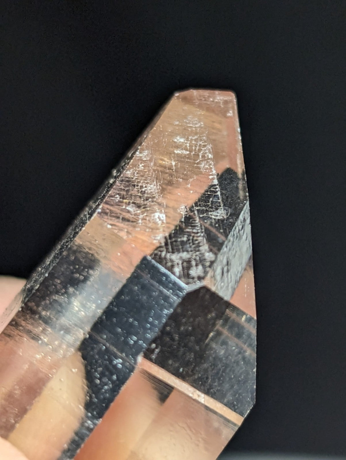 A translucent, faceted quartz crystal with a pointed tip and visible internal inclusions.