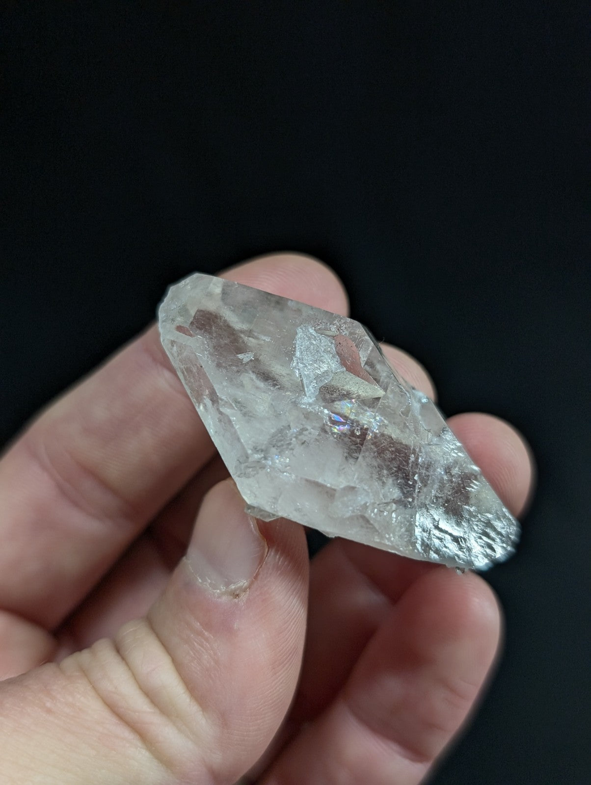 A translucent, clear quartz crystal with a rough, faceted surface and subtle internal inclusions.