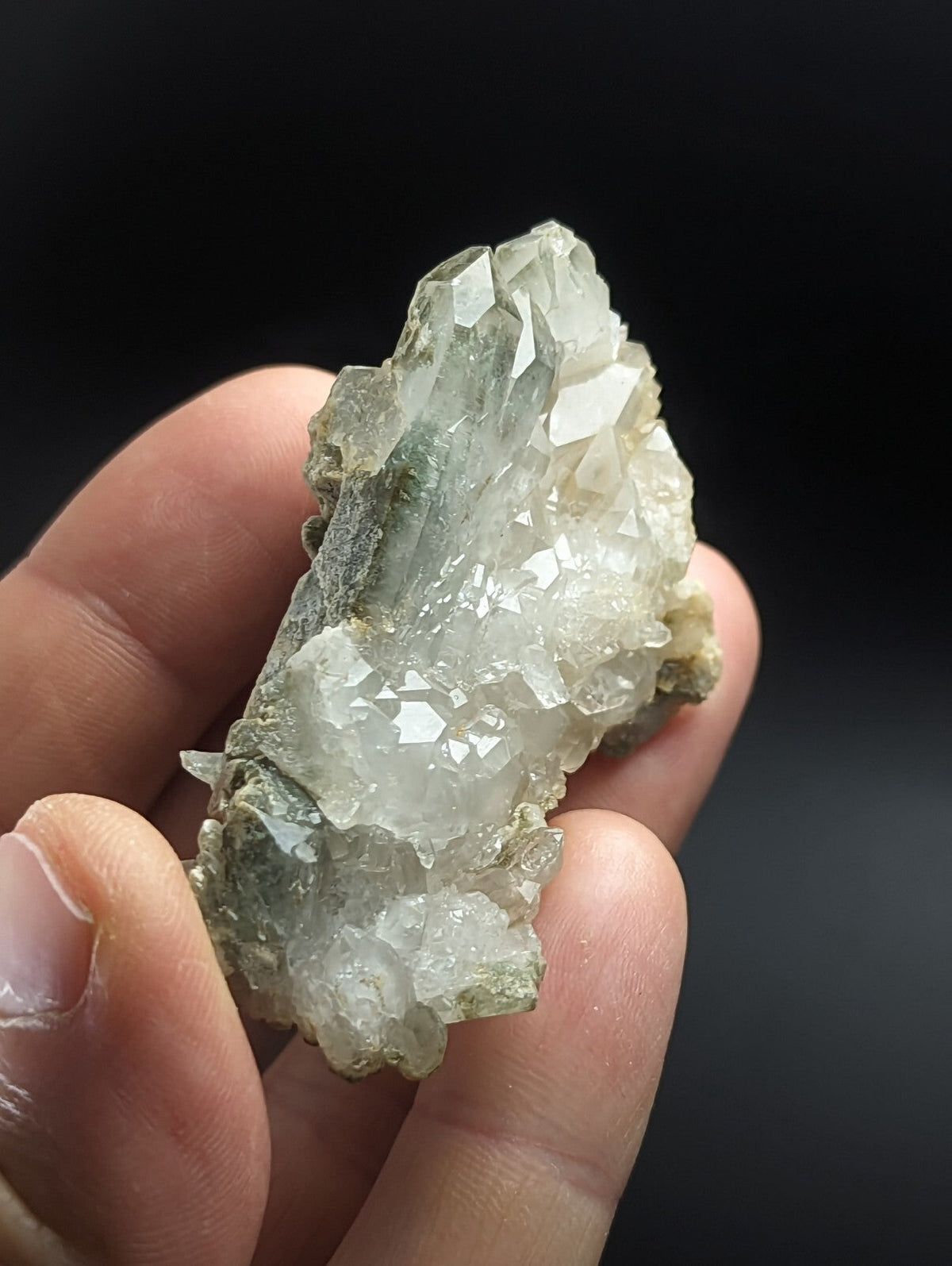 A translucent, pale green and white mineral specimen with sharp crystalline facets.