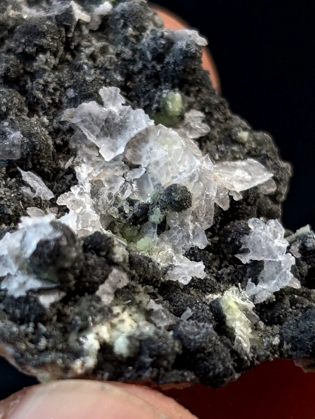 A rugged mineral specimen featuring translucent, crystalline formations embedded in a dark, earthy matrix.