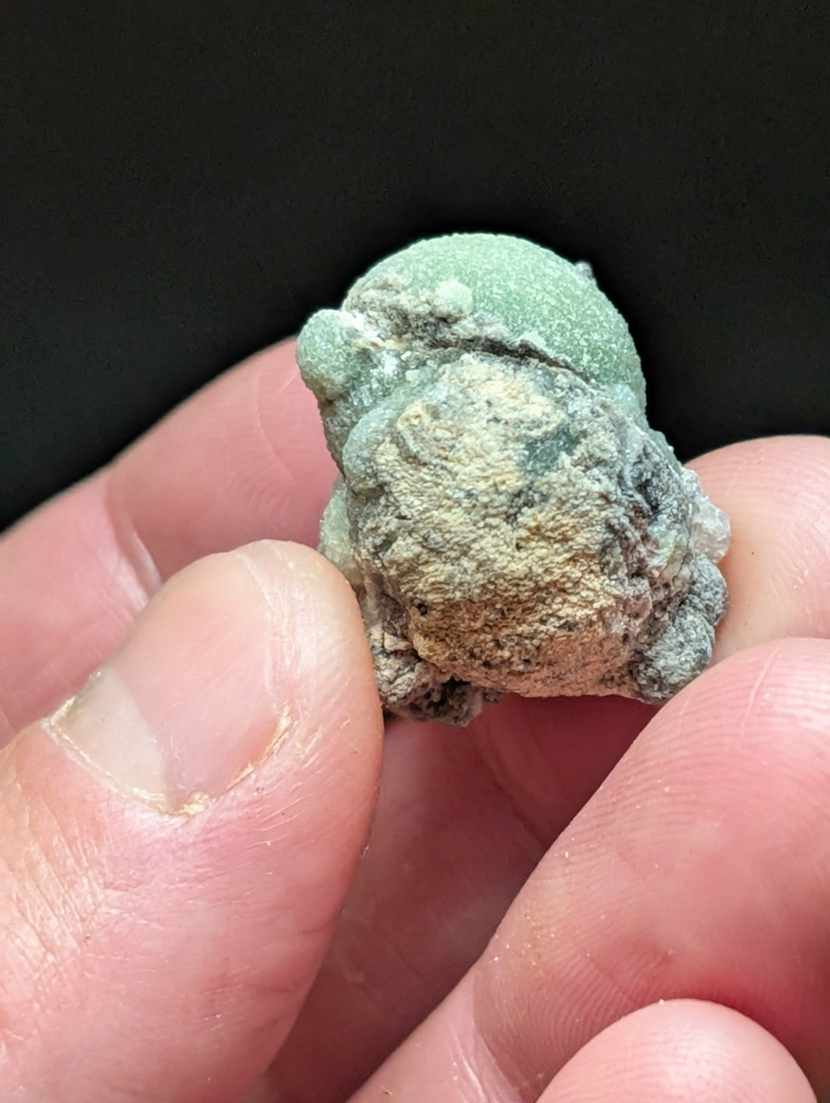 A mossy, textured frog figurine with a greenish patina and patches of beige and gray.