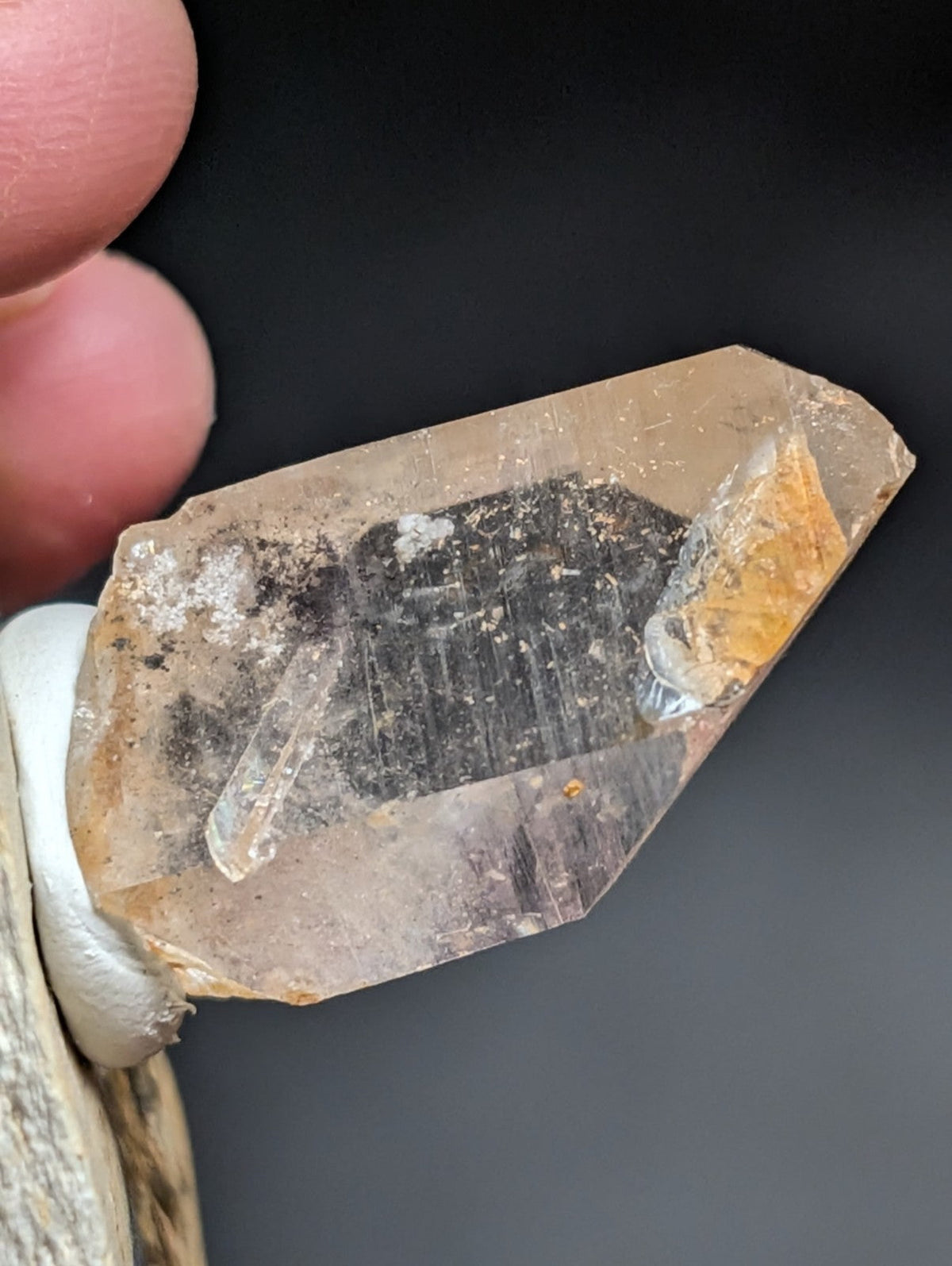 A translucent, amber-hued quartz crystal with a rough, natural surface and visible internal inclusions.