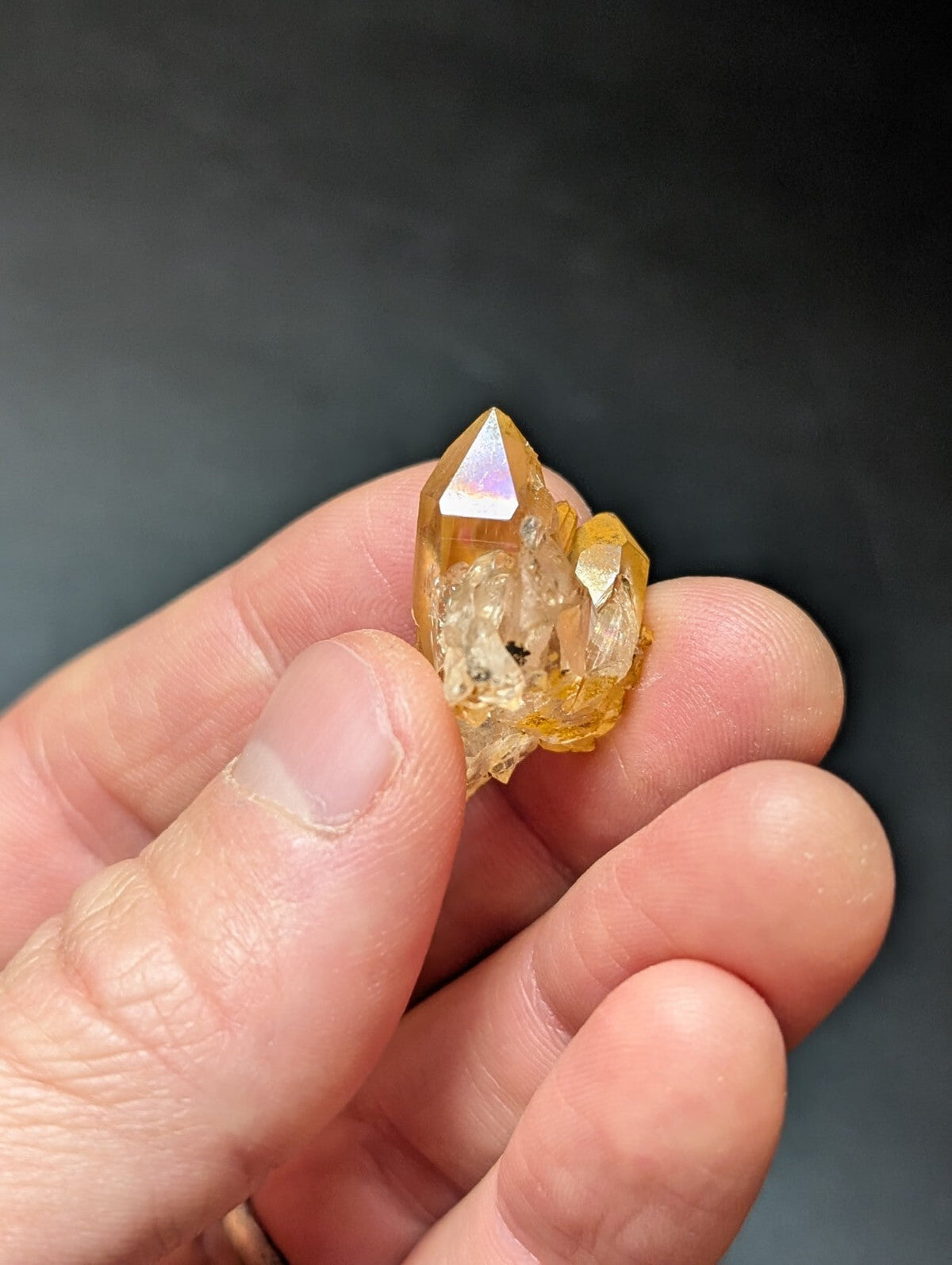 A translucent golden-yellow crystal cluster with a pointed, faceted top and rougher base.