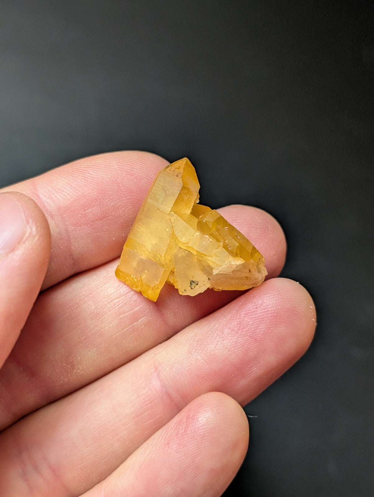 A translucent yellow crystal cluster with sharp, angular facets and a natural, irregular shape.