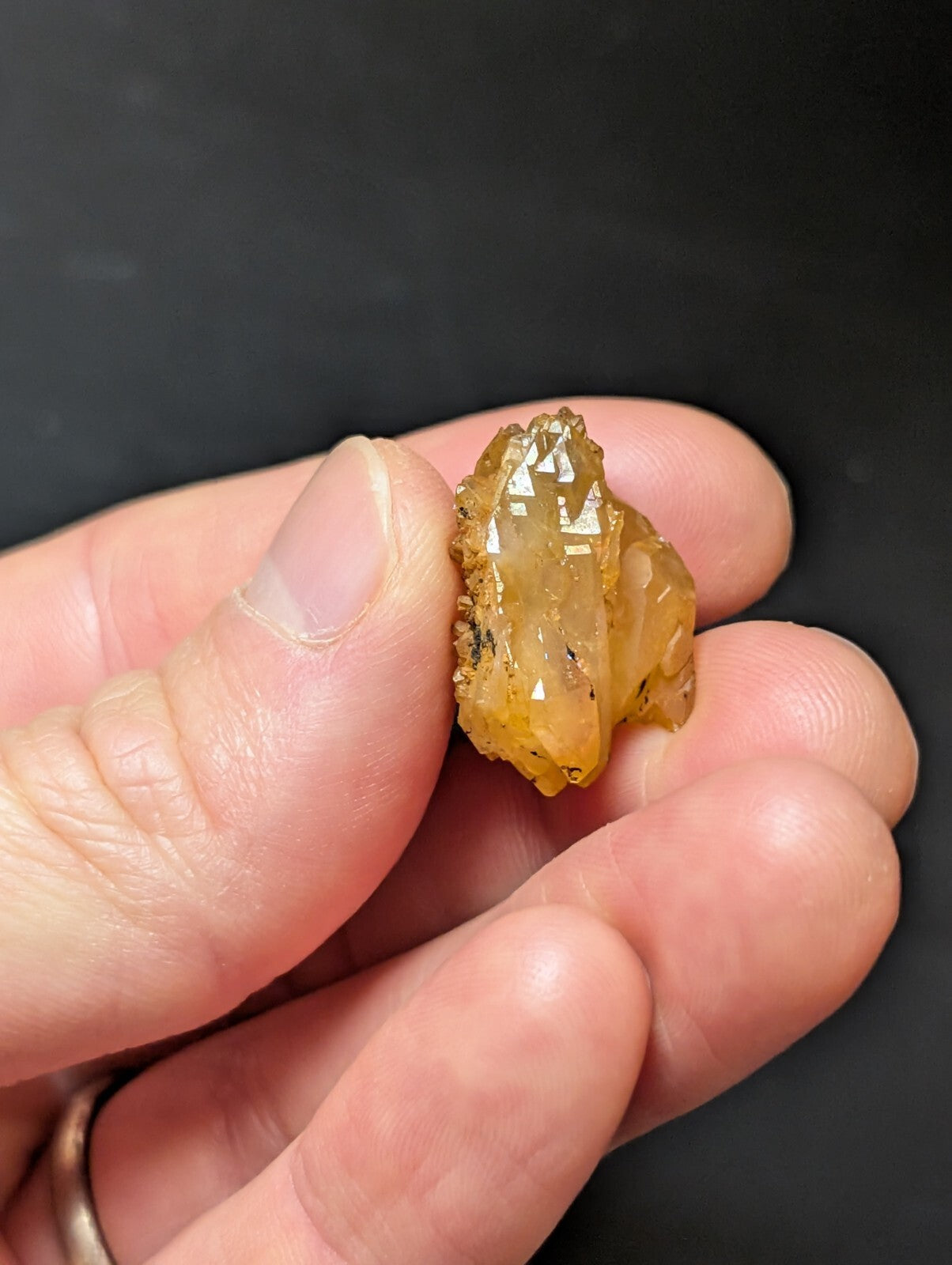 A translucent amber-colored crystal with a rough, jagged surface and visible internal inclusions.