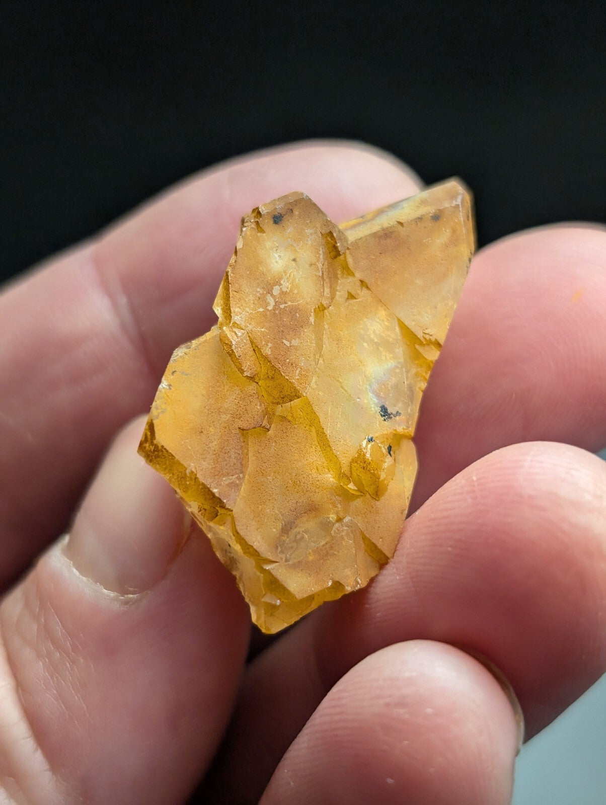 A translucent amber-colored mineral specimen with jagged, crystalline facets and subtle internal inclusions.