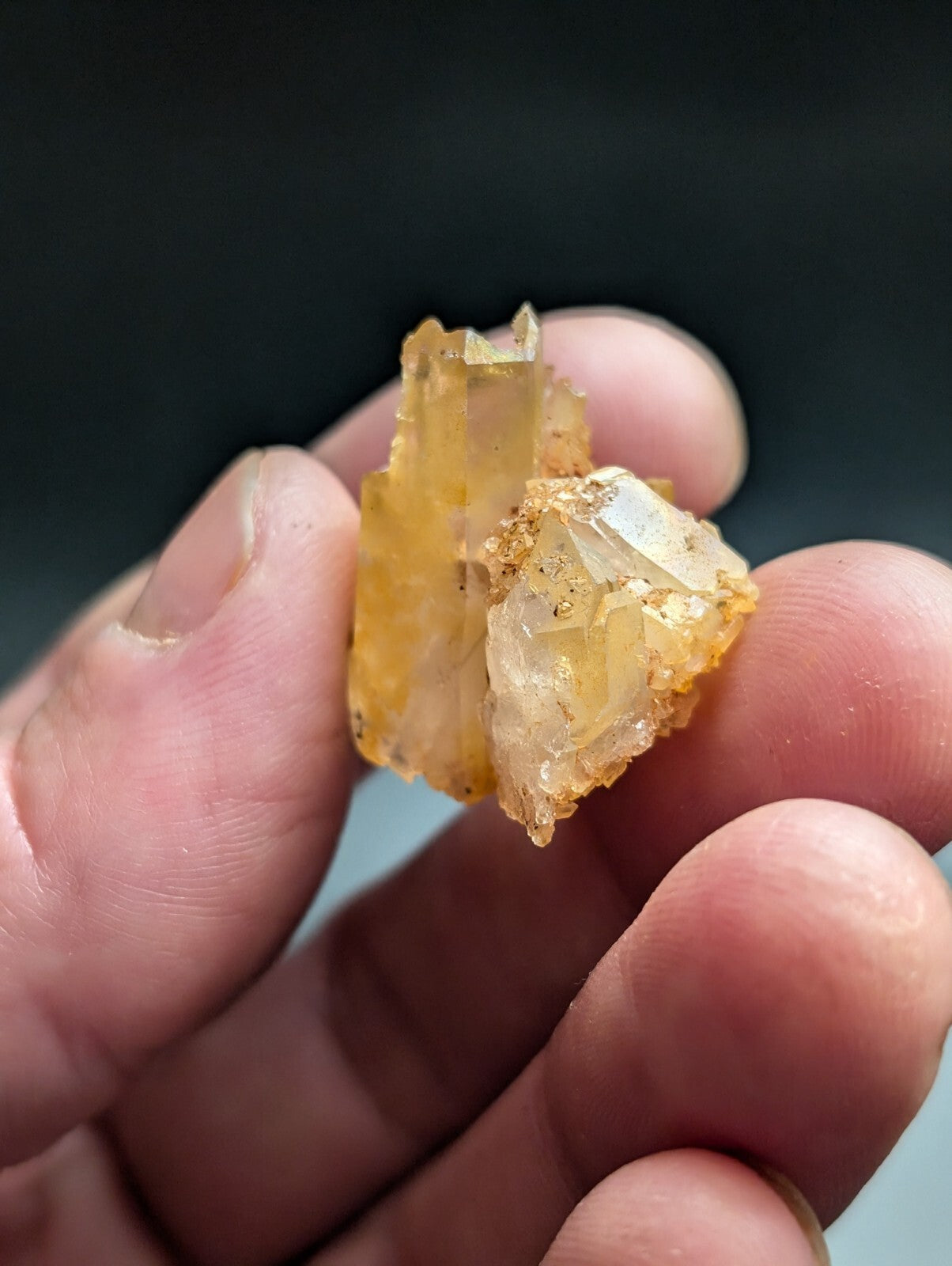 A translucent amber-colored crystal cluster with jagged, faceted edges and a slightly rough texture.