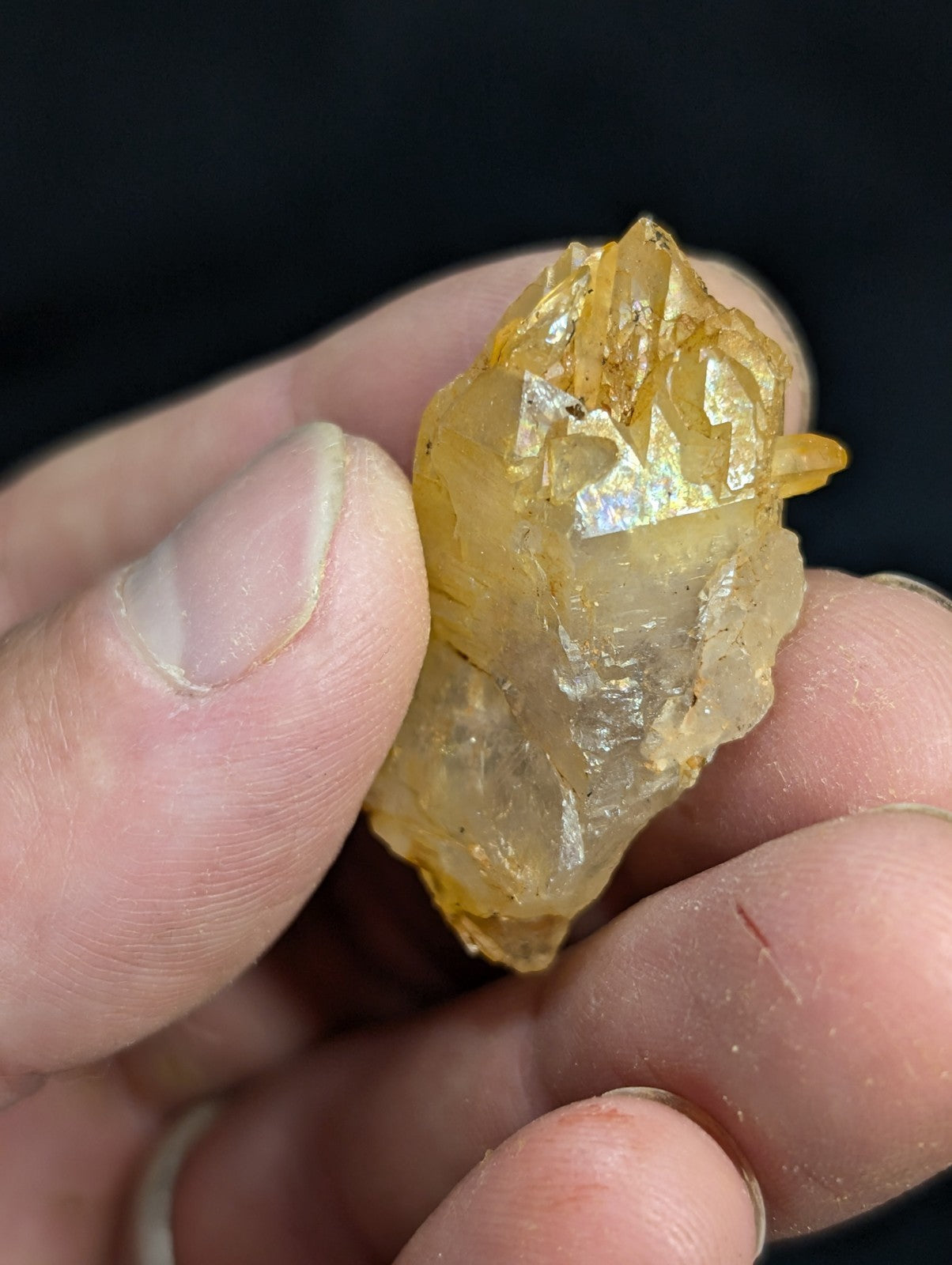 A translucent golden-yellow crystal with sharp, jagged edges and a faceted surface.