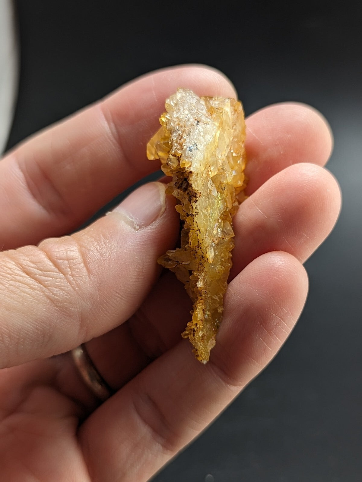 A translucent amber-colored crystal cluster with a rough, jagged surface and subtle internal inclusions.