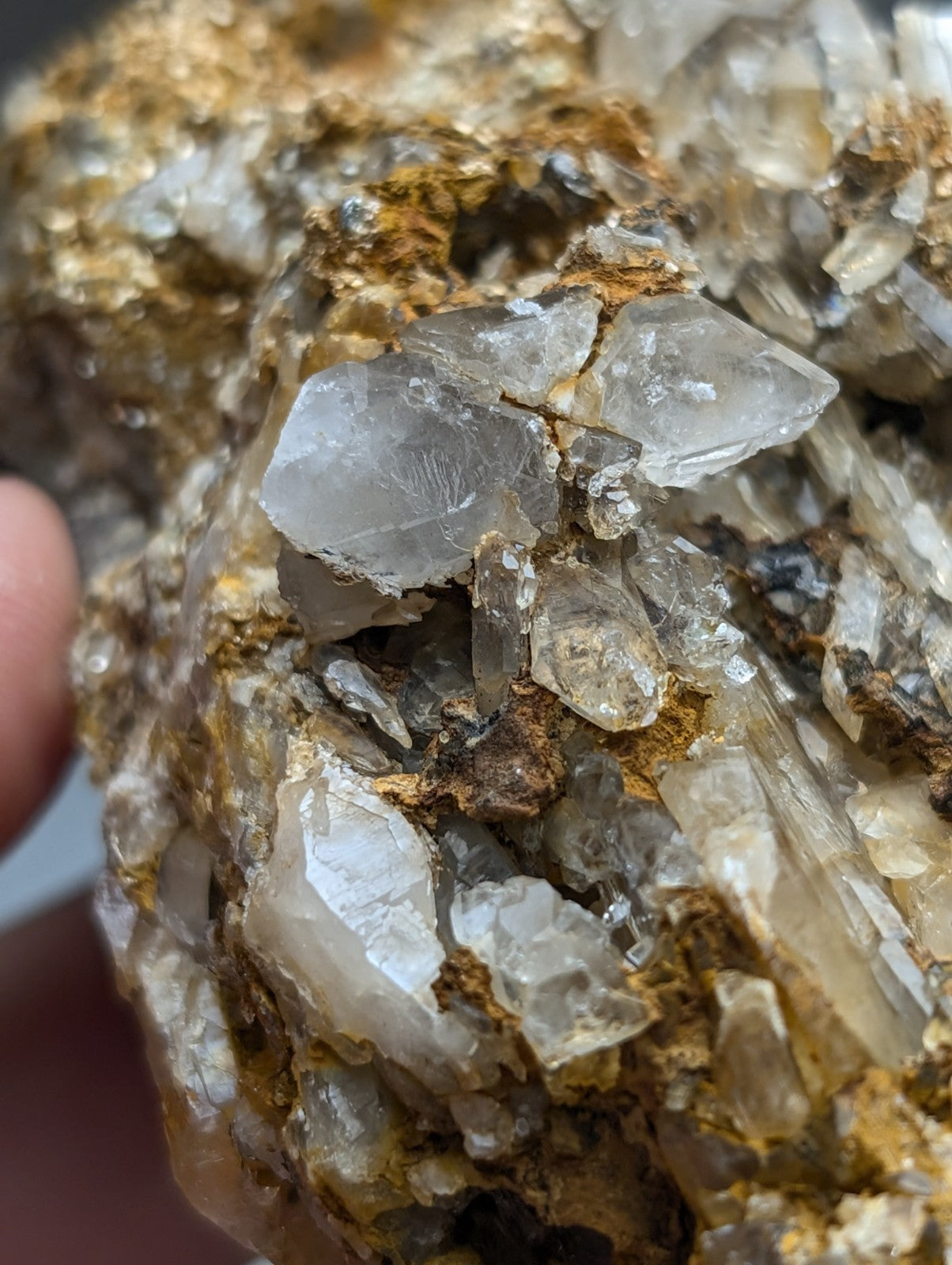 A cluster of translucent quartz crystals with golden-brown cookeite mineral matrix from saline county arkansas