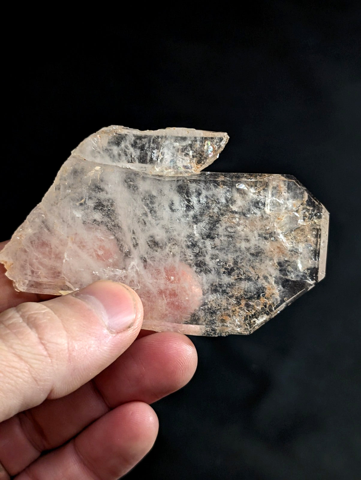 A translucent, irregularly shaped quartz crystal with visible internal inclusions and a slightly rough, jagged surface.