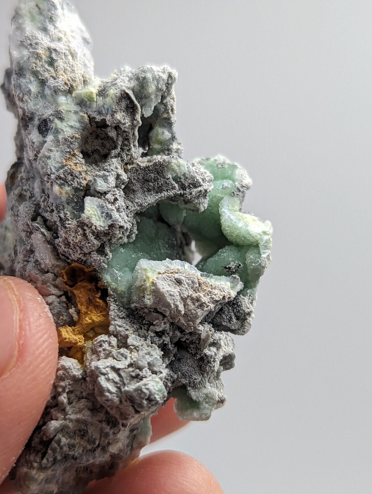 Rough mineral specimen with green inclusions.
