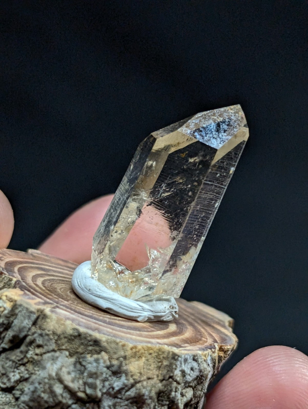 A translucent, faceted quartz crystal with a pale yellow hue and subtle internal inclusions.