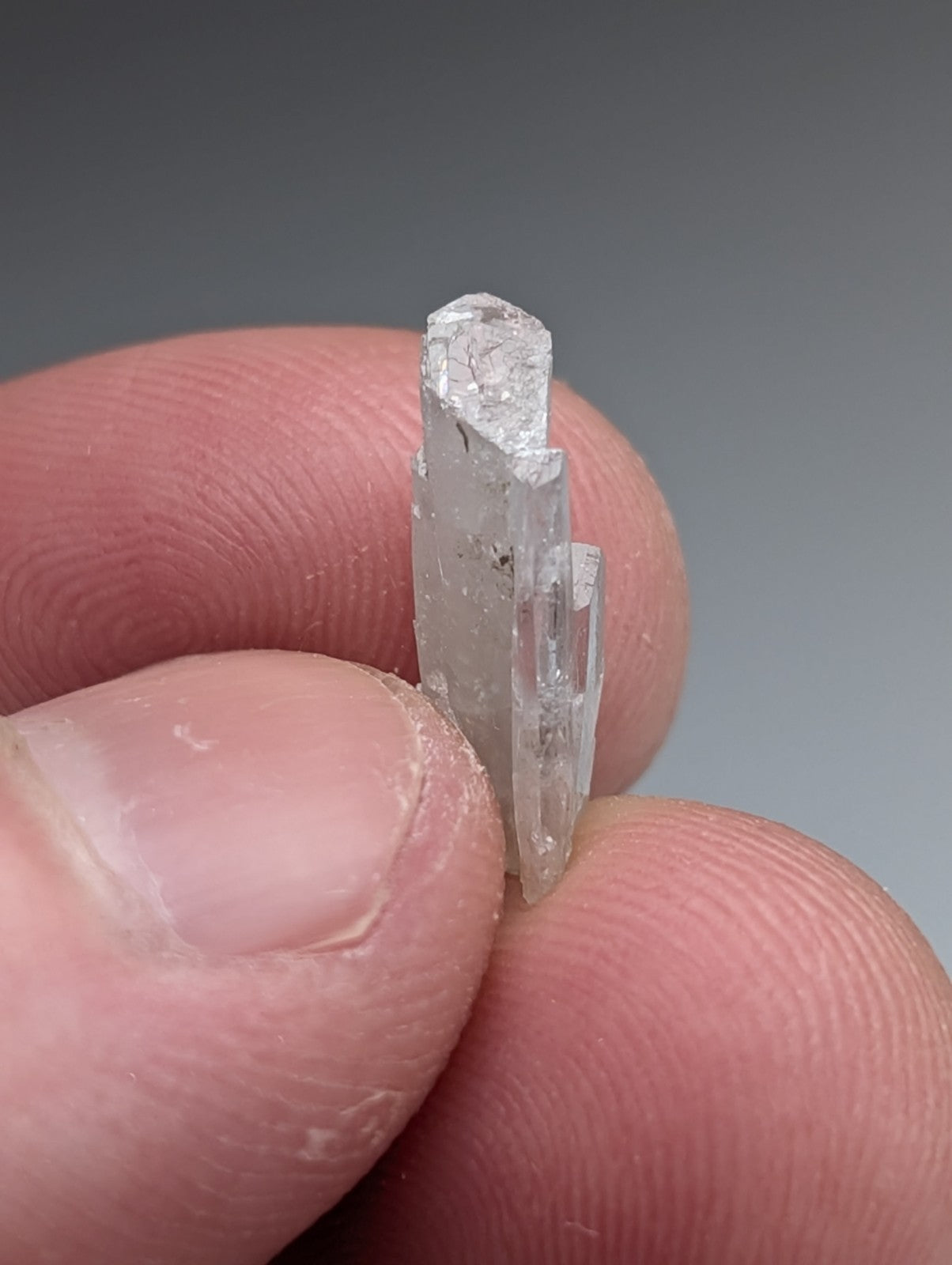 A translucent clear quartz barite crystal with faceted top and natural striations from Magnet Cove Arkansas in a case