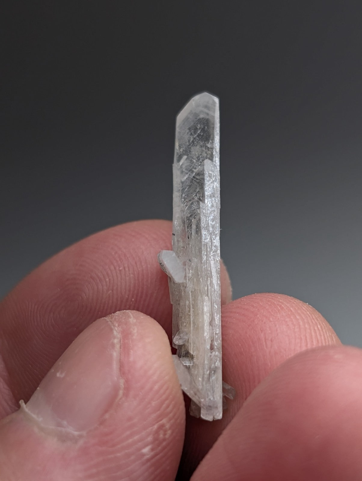 A translucent clear quartz crystal with pointed tip and internal striations from magnet cove arkansas with case
