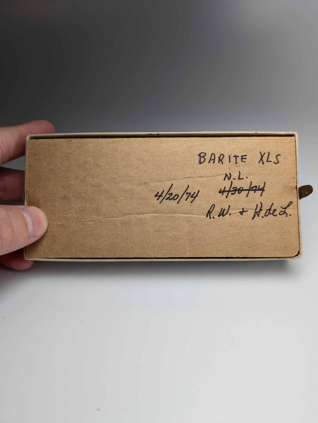 A rectangular brown cardboard box with handwritten labeling containing a+ barite crystal from chamberlain creek arkansas with case