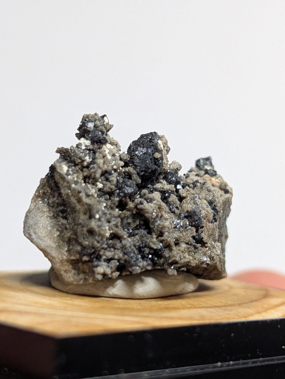 A rugged, gray and black mineral specimen with a rough, crystalline texture.