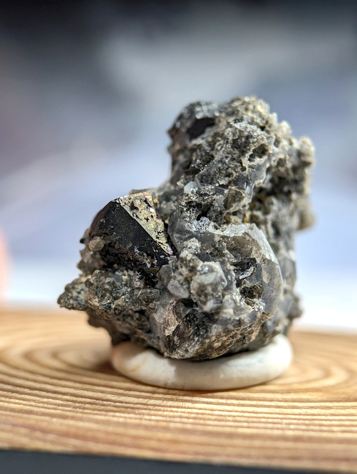 A rugged, dark gray mineral specimen with crystalline textures and a rough, uneven surface.