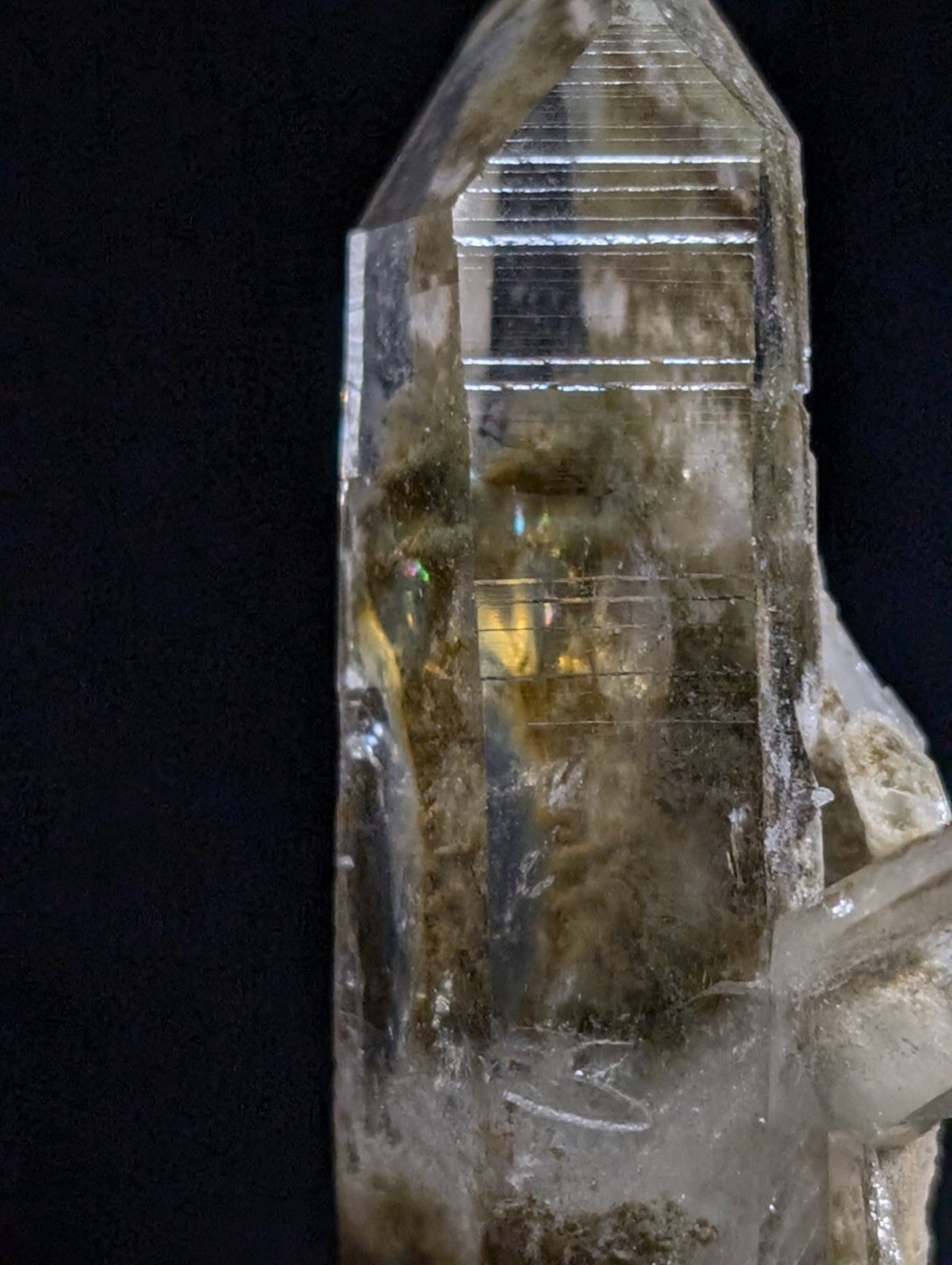 A translucent, clear quartz crystal with a pointed tip and visible internal inclusions.