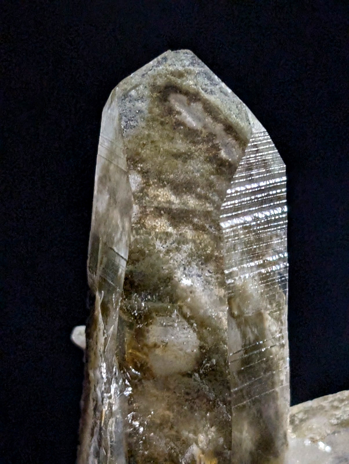 A translucent, clear quartz crystal with natural inclusions and striations.