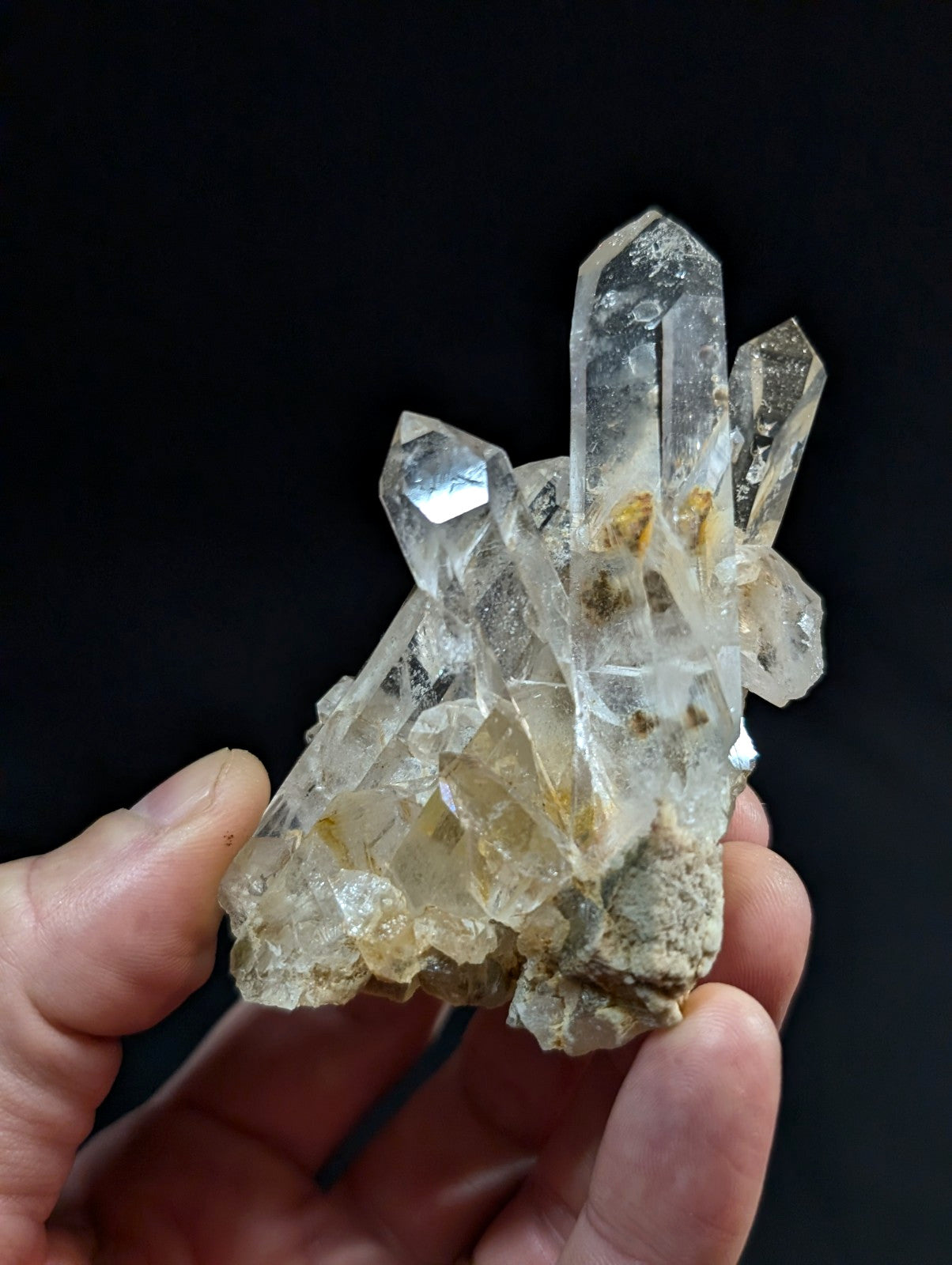 A translucent quartz crystal cluster with clear, pointed facets and subtle yellowish inclusions.