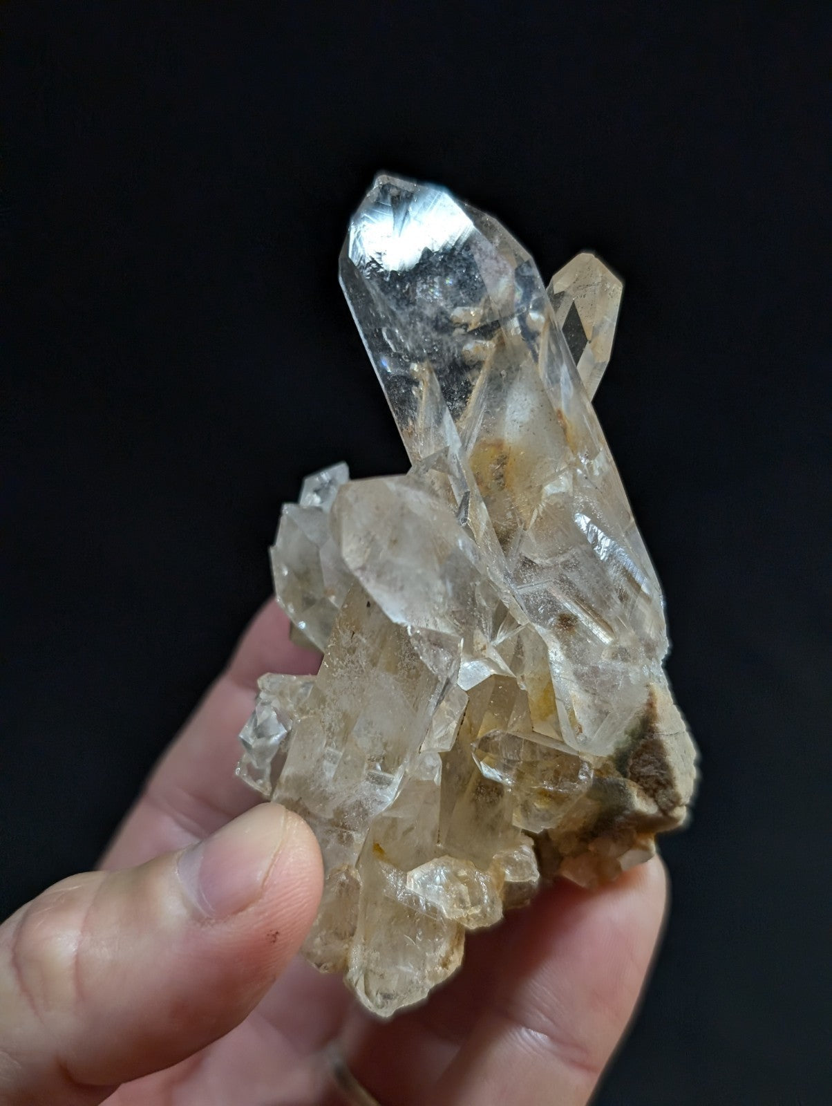 A translucent quartz crystal cluster with clear, faceted points and a slightly cloudy base.