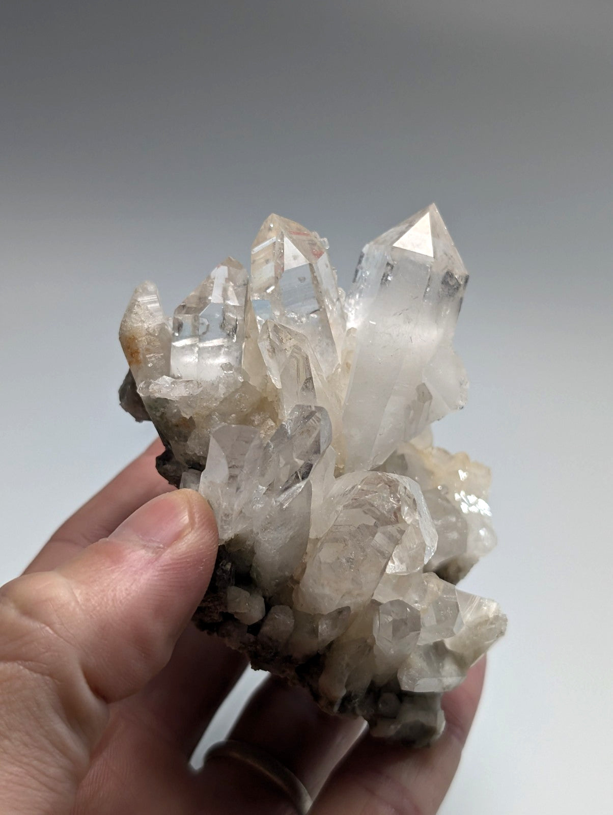 A translucent quartz crystal cluster with sharp, pointed facets and a mix of clear and milky white tones.