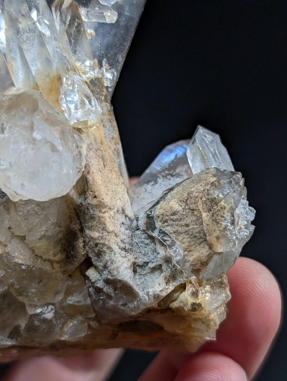 A cluster of clear, translucent quartz crystals with some exhibiting a subtle yellowish tint and others displaying faint gray veining.