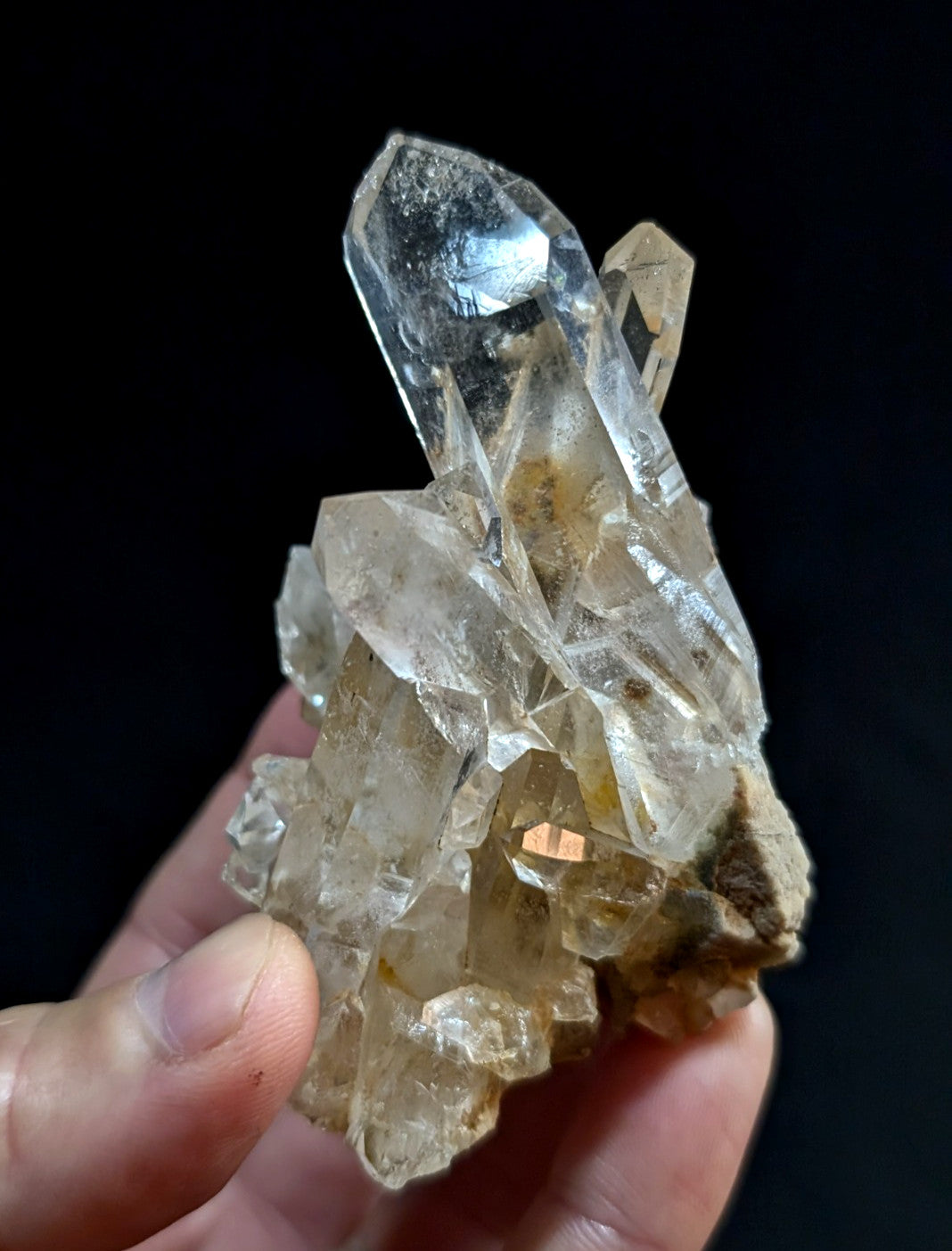 A clear quartz crystal cluster with sharp, faceted points and a translucent body.