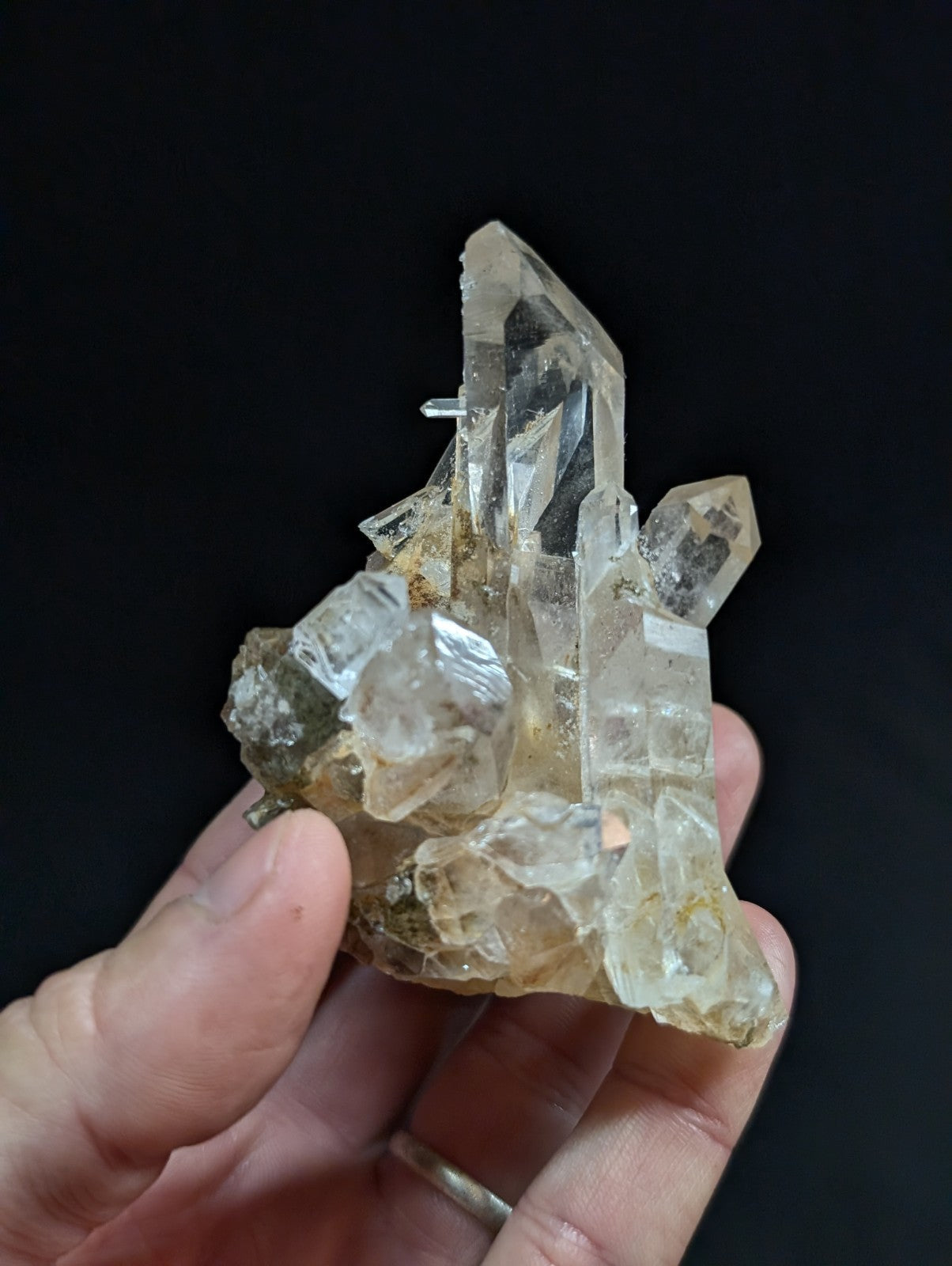 A translucent, clear quartz crystal cluster with sharp facets and a slightly yellowish tint at its base.