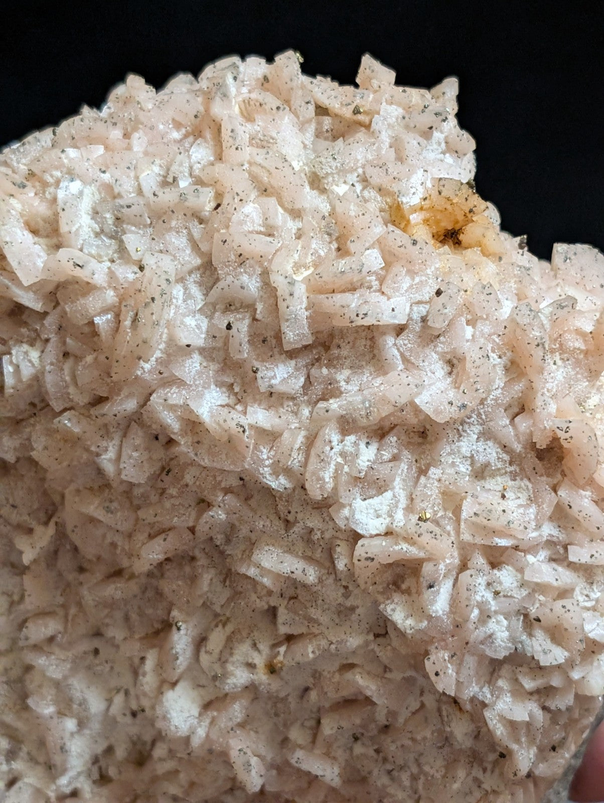 A cluster of translucent, pale pink crystalline formations with subtle speckles and a slightly rough texture.