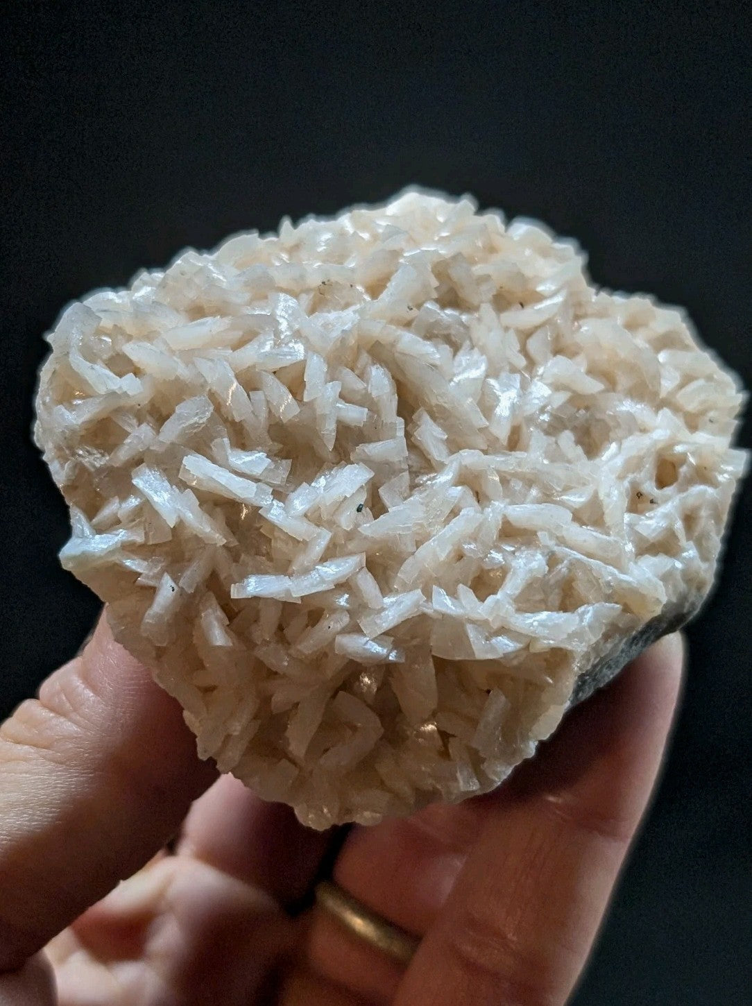 A translucent white quartz crystal cluster with a rough, textured surface held in hand.