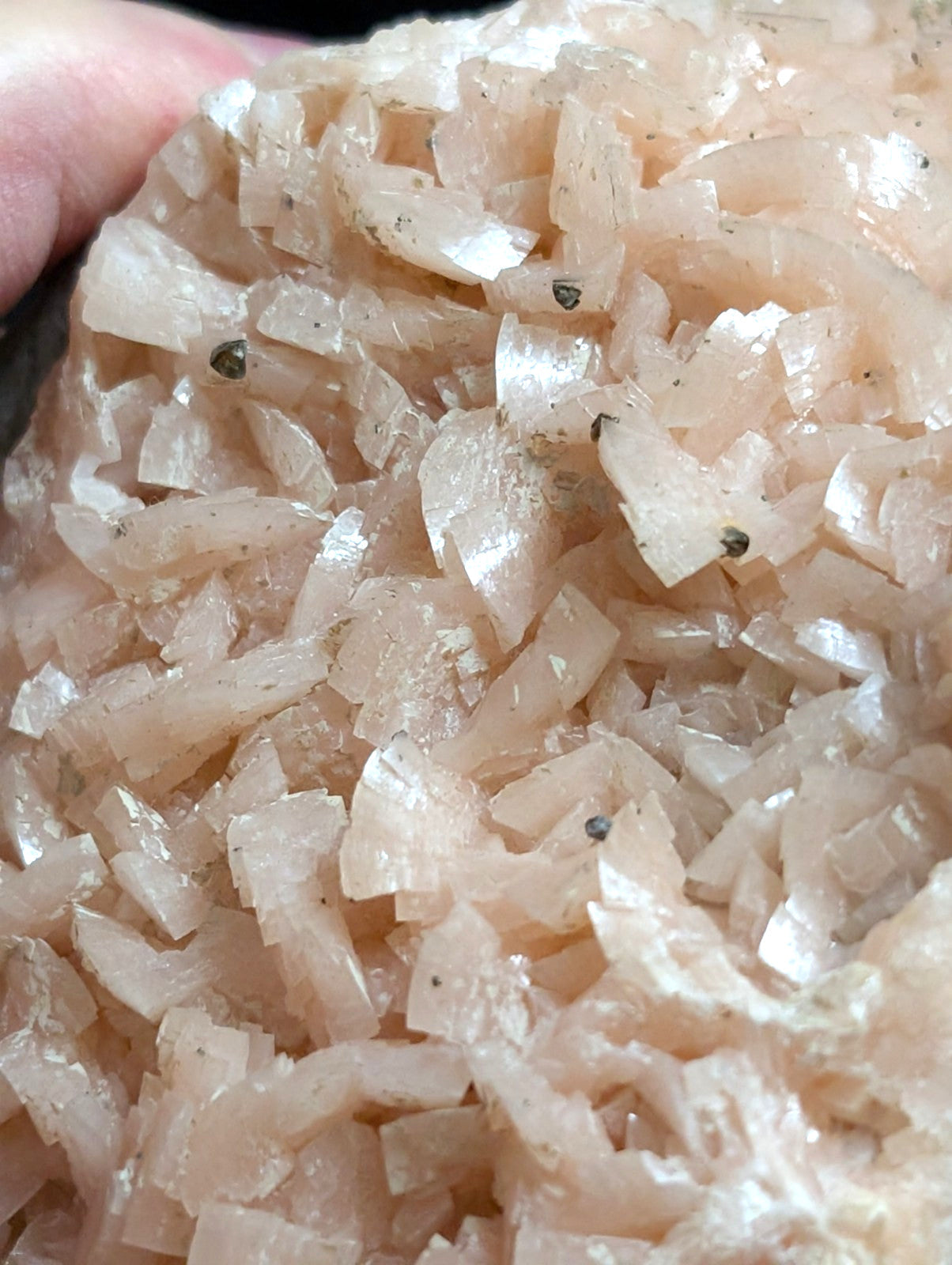 A cluster of translucent, pale pink crystalline minerals with sharp edges and a slightly rough texture.