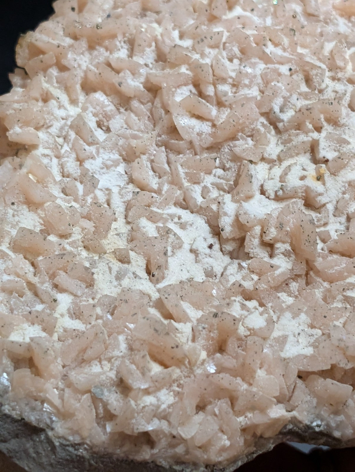 A cluster of translucent, pale pink crystals with a crystalline texture and subtle speckles.