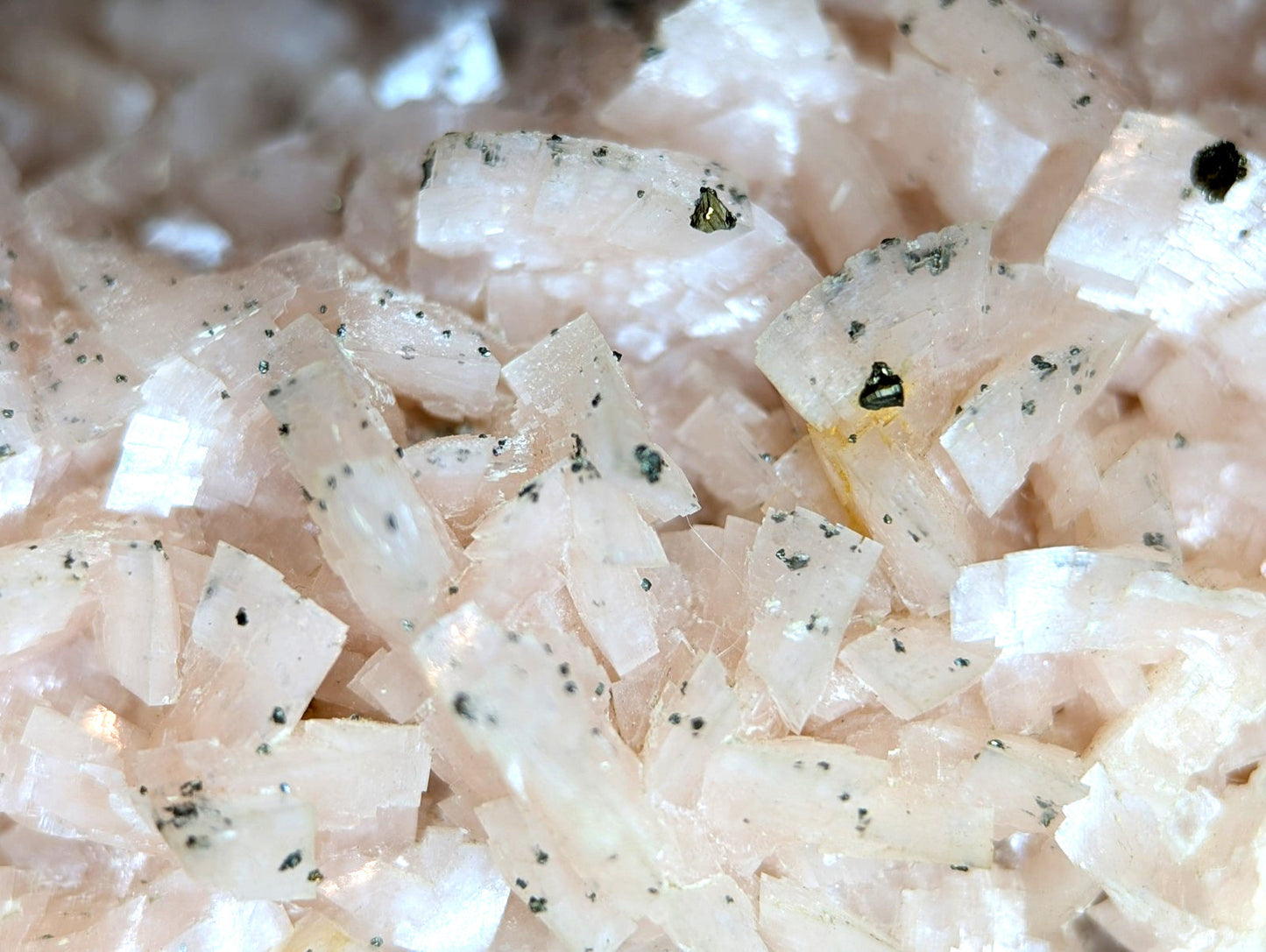Pink translucent crystal fragments with dark speckles.