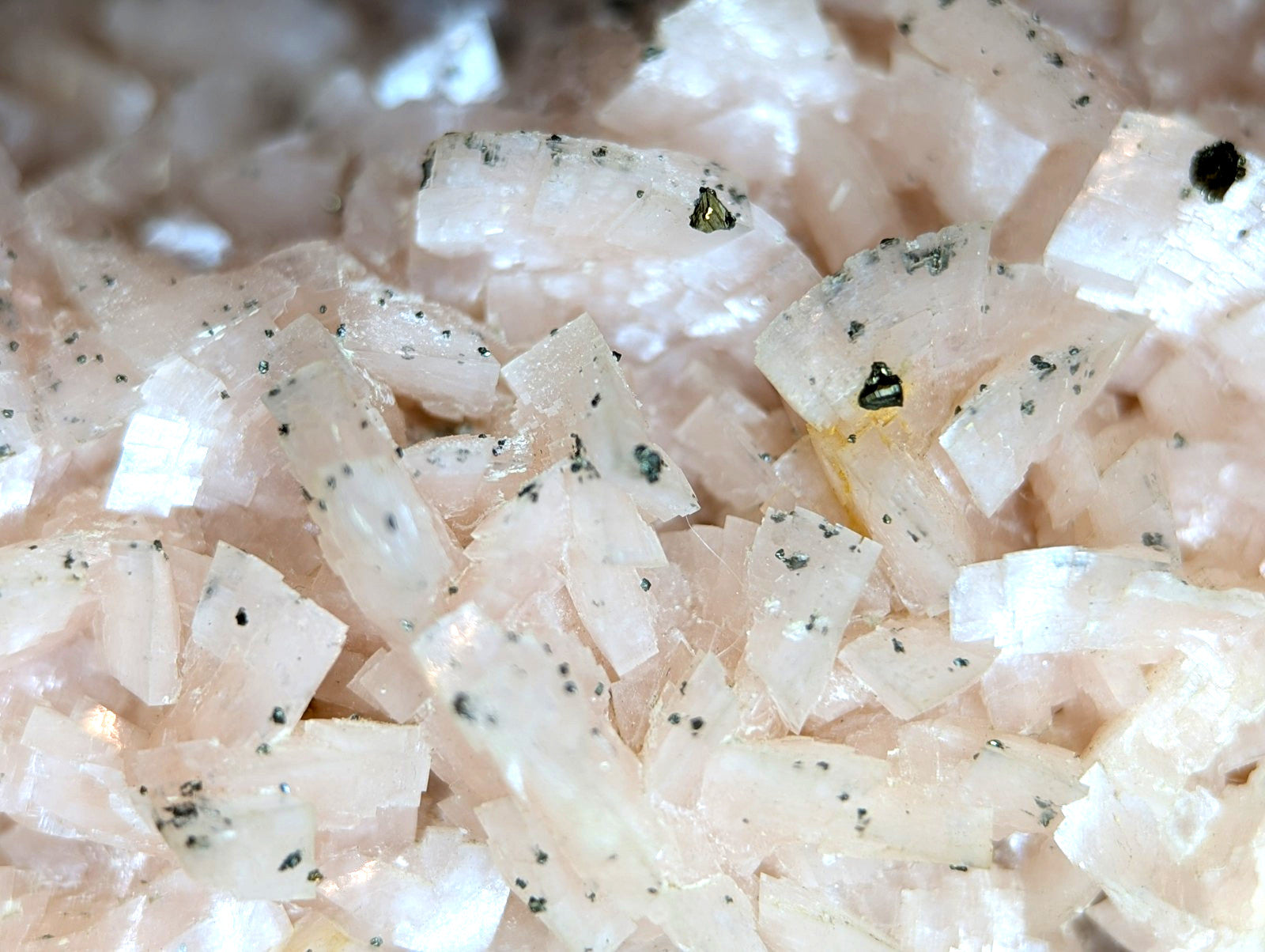 Pink translucent crystal fragments with dark speckles.