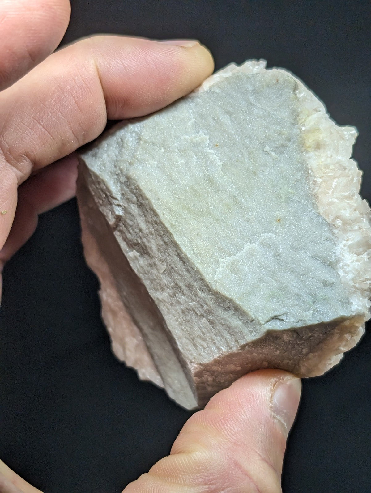 A rough, irregularly shaped grayish-white rock with a slightly translucent and crystalline texture.