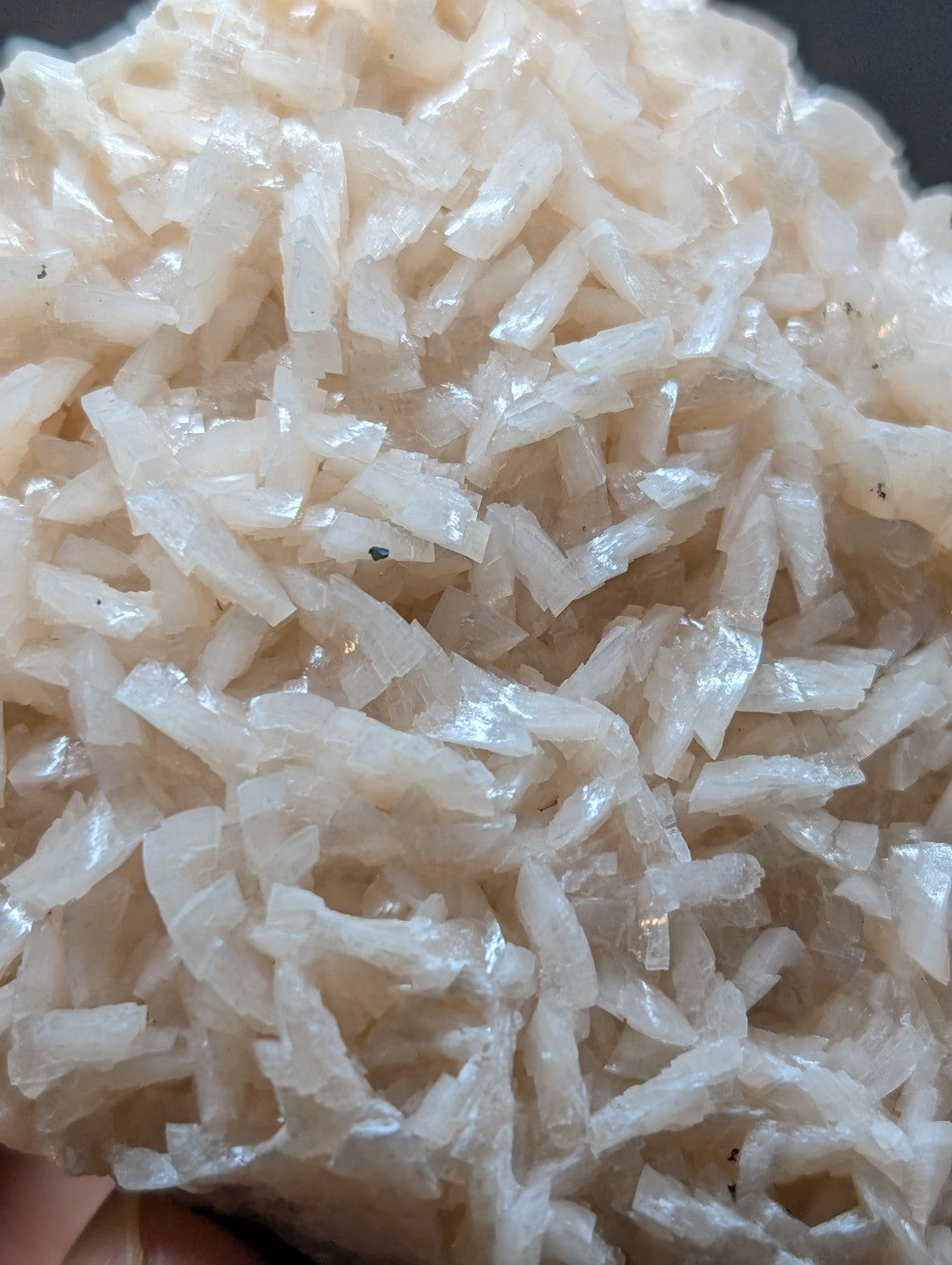 A translucent, off-white, crystalline rock formation with jagged, interlocking fragments.