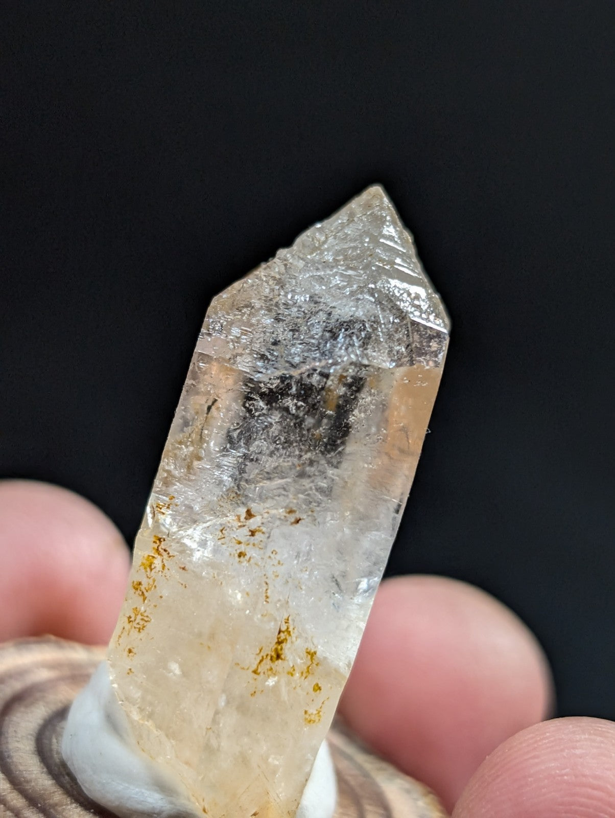 A translucent, pale yellowish quartz crystal with subtle golden inclusions and a pointed tip.