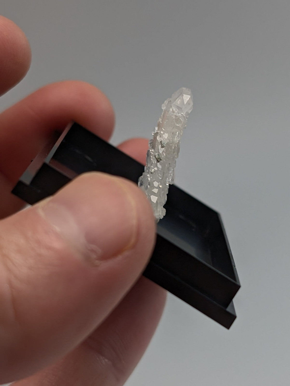 A translucent faceted faden quartz crystal cluster with clear and cloudy appearance in a photo case mount from saline county arkansas usa