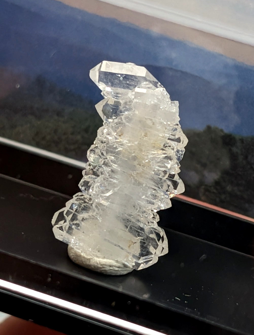 A clear, faceted quartz crystal cluster with a natural, jagged formation and translucent quality.